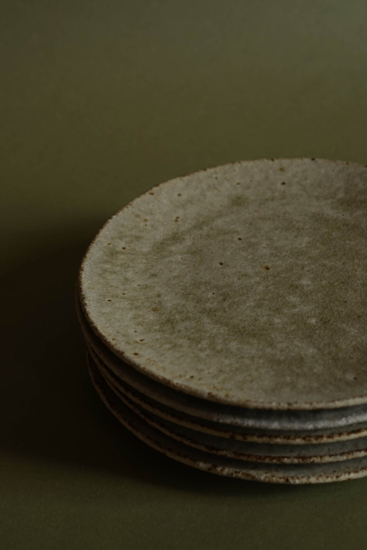 A stack of side plates by Ingot objects. Ash glazed showing a textured stoneware underneath 