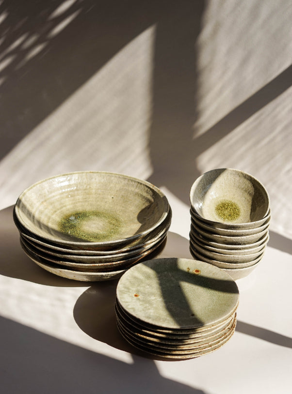 A range of Jonathan's ash glazed crockery. From left to right are platters, side plates and bowls.