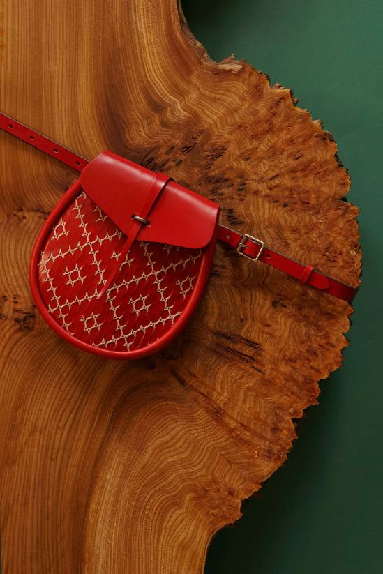 Red handcrafted leather sporran bag by Iseabal Hendry. With white lace work panel.