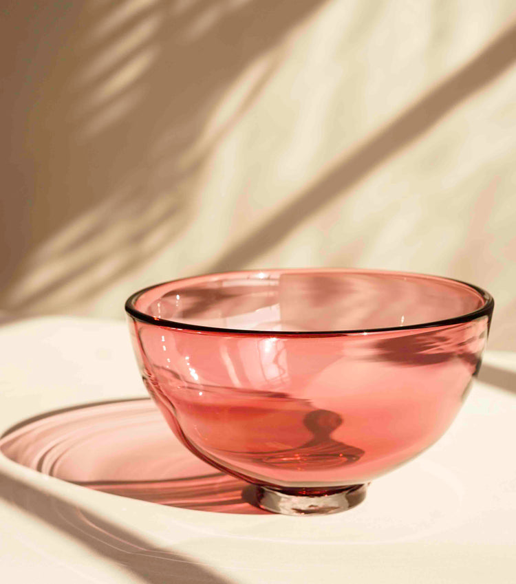 A Lindean Mill Glass Gem Bowl in blush pink, with a thick foot which makes it appear to float above the surface of the table.