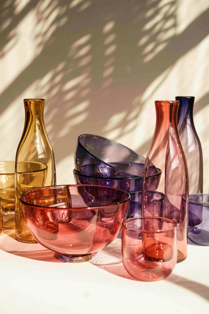 A range of coloured glassware by Lindean Mill. A selection of gem bowls, cups and carafes 