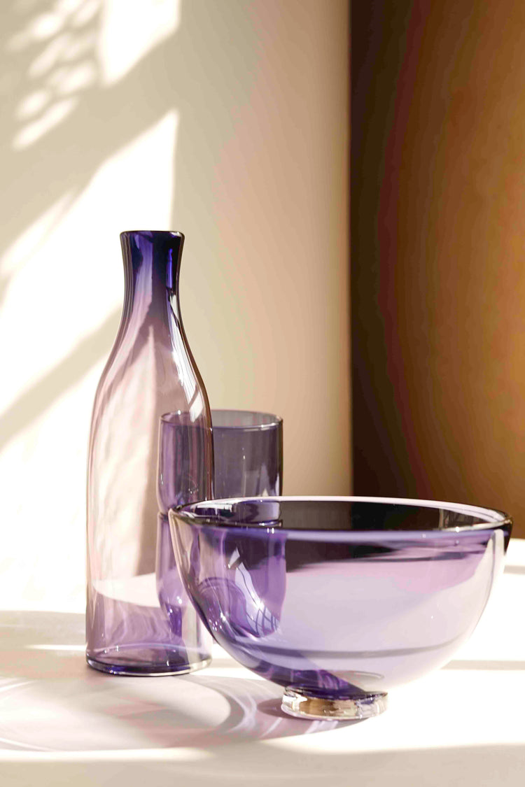 A selection of violet purple glassware; a carafe, two cups and a gem bowl. All handblown by Lindean Mill, and photographed at Bard Scotland.