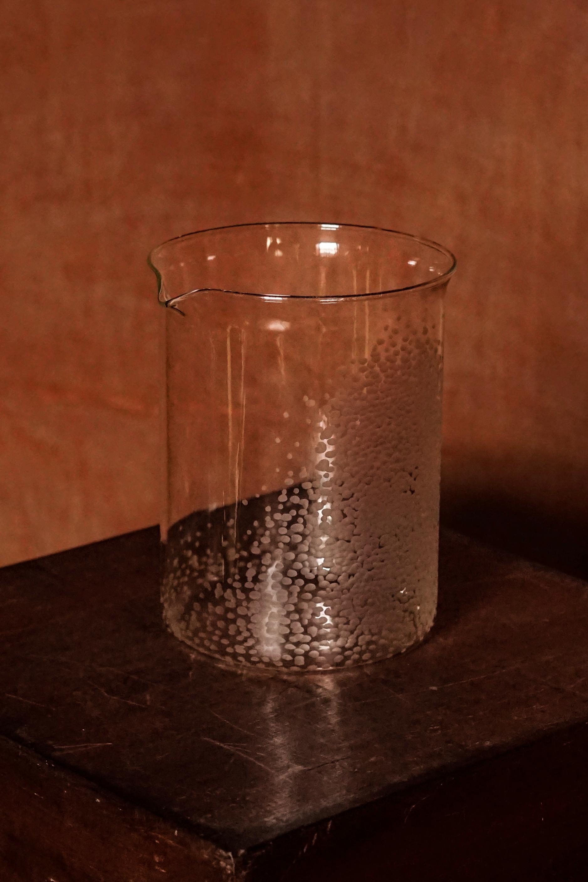  The Large Beaker, part of Second Lives by Juli Bolaños-Durman. Placed on top of a wooden surface.