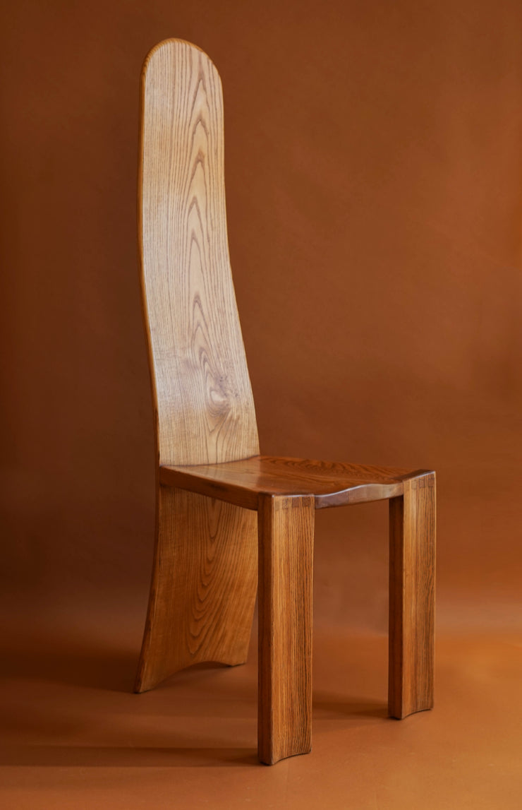 A 1970's high backed chair. Made in elm with with carved seats and curved, laminated backs.