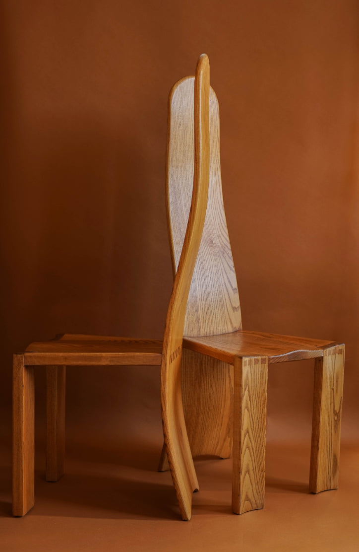 Elm high-backed chairs with carved seats and curved, laminated backs that stretch to the ground.