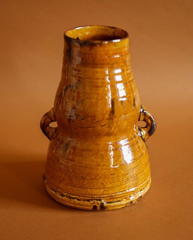 A glossy ochre glaze has been applied to this earthenware vase. Thrown by Joshua Williams.