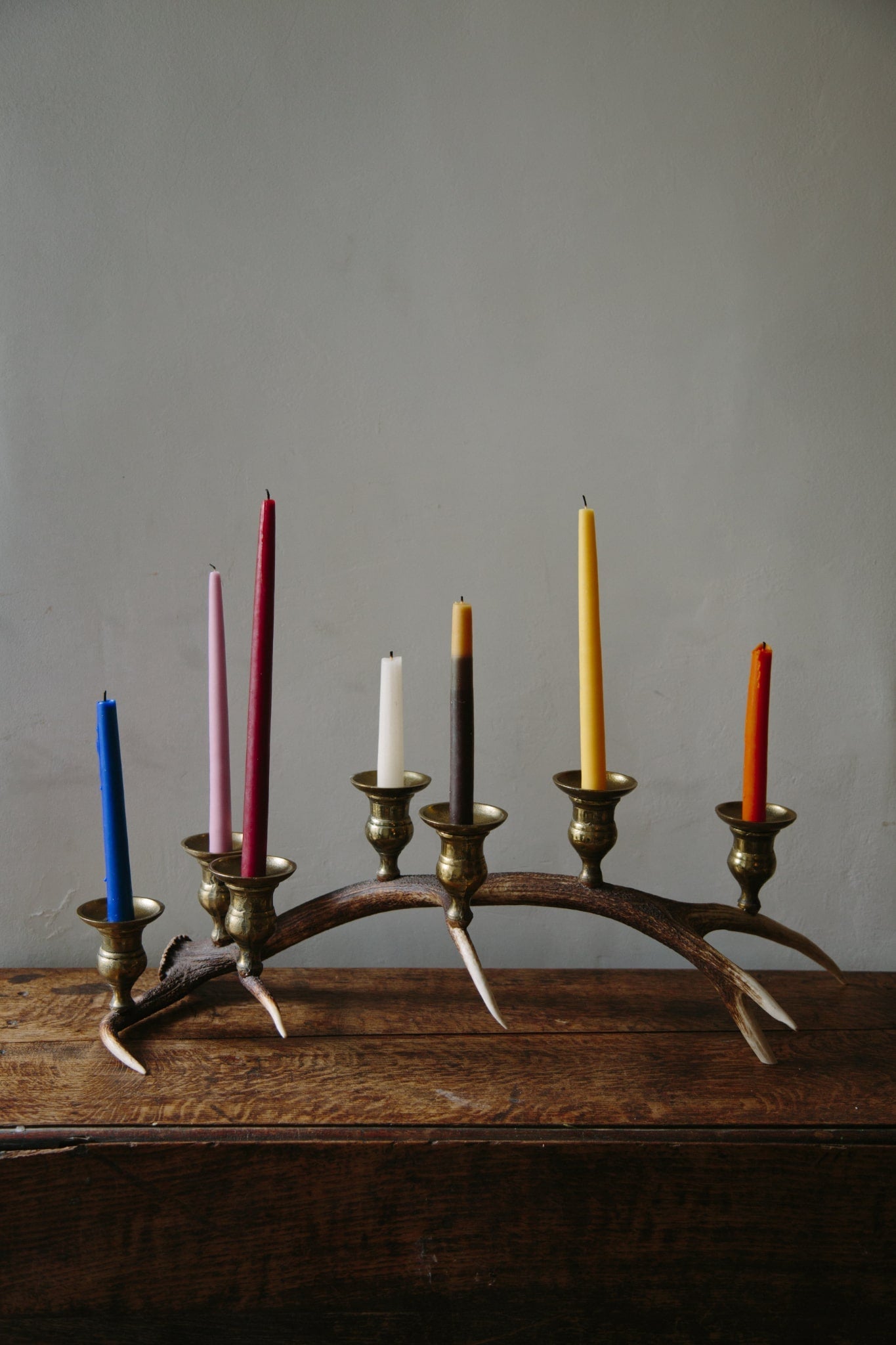 Candelabra made from a Scottish antler and with seven brass candlestick cups. Shot filled with bright coloured candles, just blown out.