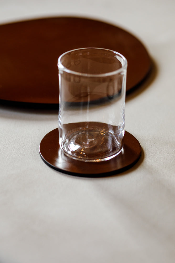 Bridle leather coasters by McRostie Leather of Scotland. Shot here with a single glass tumbler.