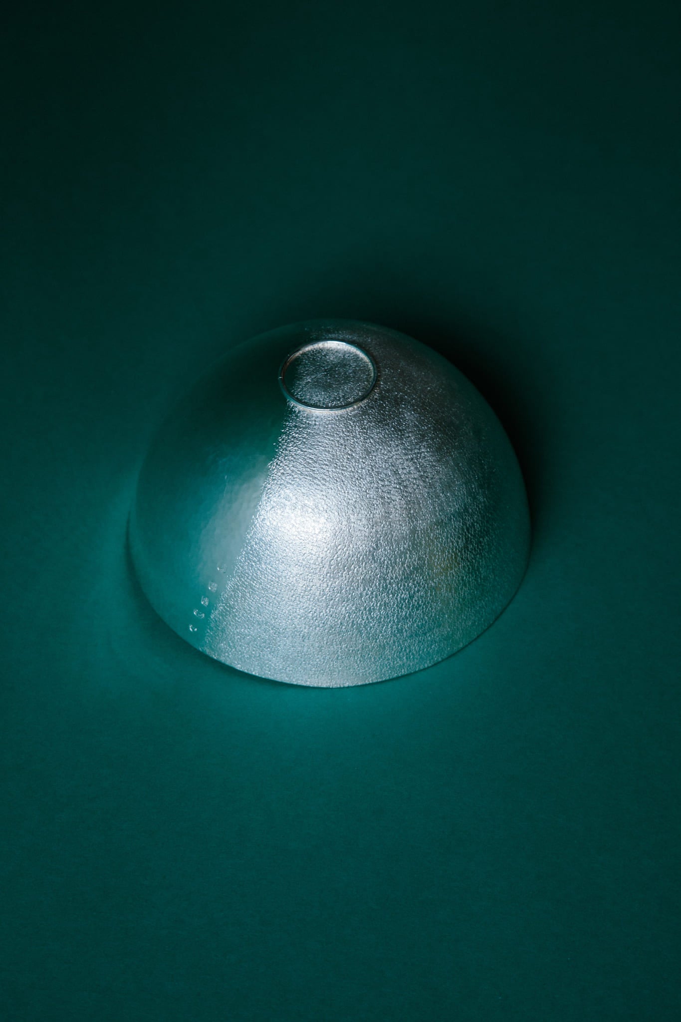 The underside of a hand raised sterling silver bowl with a matt textured finish.