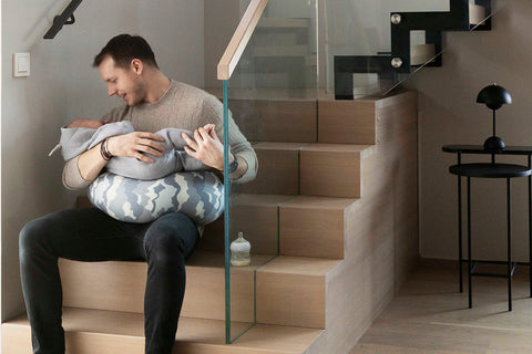 dad feeding baby with a nursing pillow