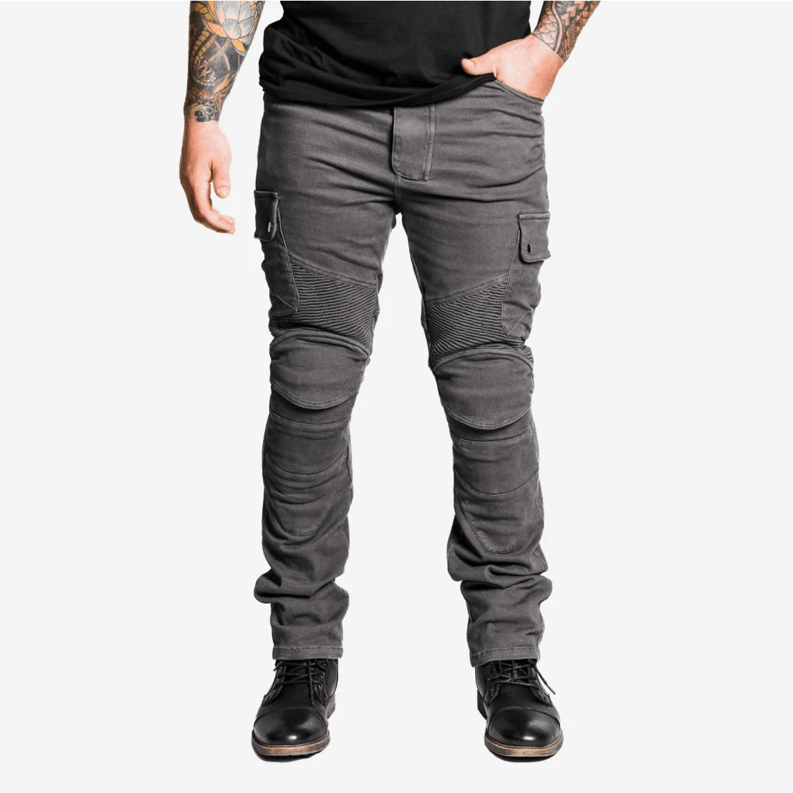 Person wearing black cargo pants and boots, with tattooed arms visible.