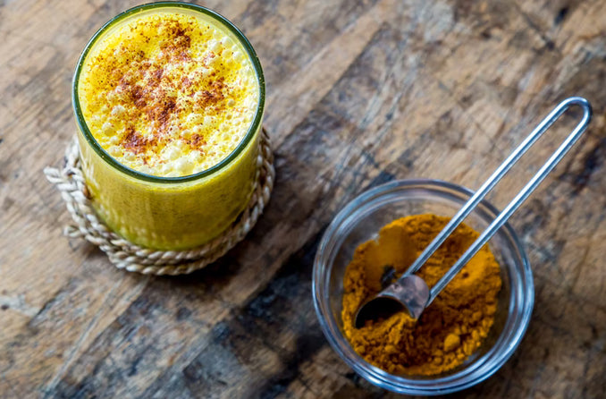 Turmeric Latte Alongside Ground Turmeric Powder