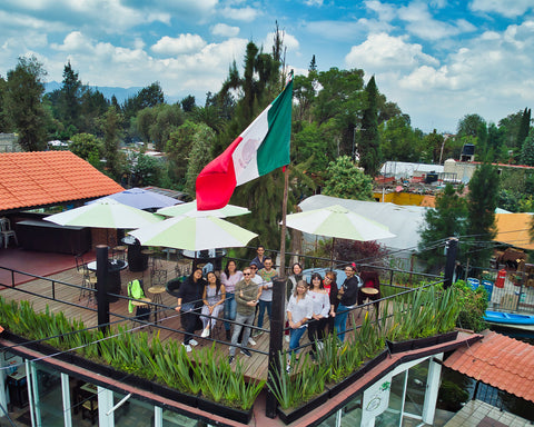 Equipo Alxedo en restaurante con bandera de México.