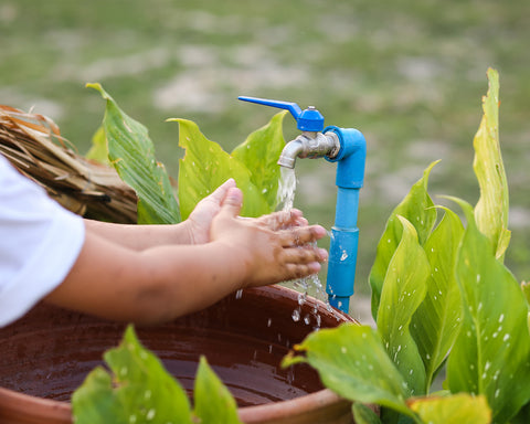 Manos limpiandose con llave de agua limpia.