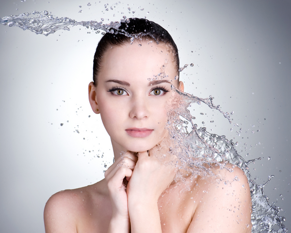 Agua cayendo sobre el rostro de una mujer 