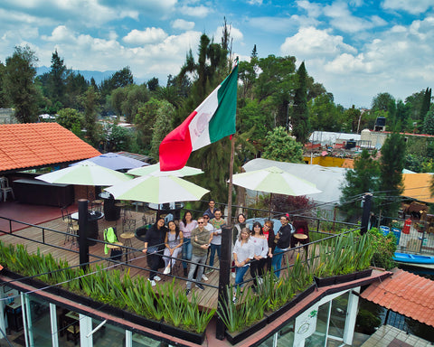 Equipo Alxedo sonriendo y con la bandera de México.