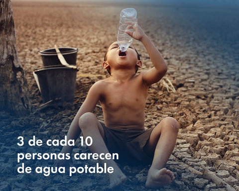 Niño tomando la última gota de agua sentado en medio de la sequía.