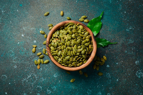 Green Pumpkin Seeds in a Wooden Bowl