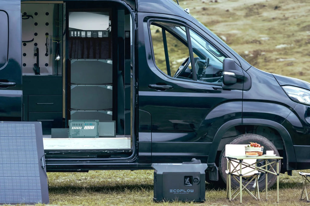 A motorhome outdoors complete with an EcoFlow power station and solar panels. An open sliding door of the van is exposing a control unit