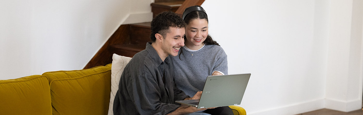 Couple sitting on couch with laptop during a virtual engagement ring consultation with Alexis Russell