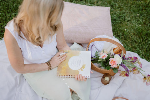 woman journaling and reflecting at a picnic