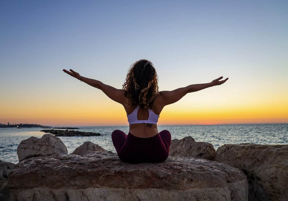 meditating in front of a sunset