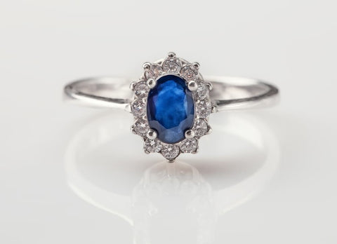 A jeweller's ring with dark blue sapphires and brilliants on a white background