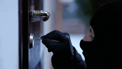 Criminal picking a door lock