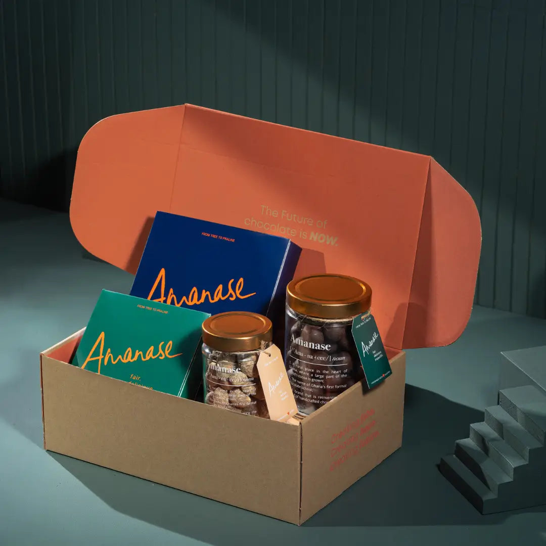 Gift box with Amanase chocolate bars and jars displayed on a teal surface.