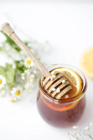 Honey spreader in a pot of honey