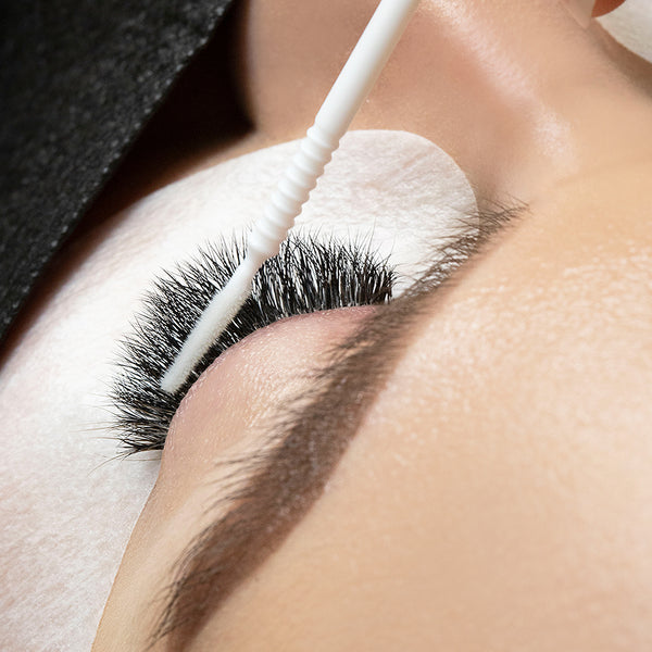 a photo showing London Lash Superbonder being applied to a finished set of lash extensions