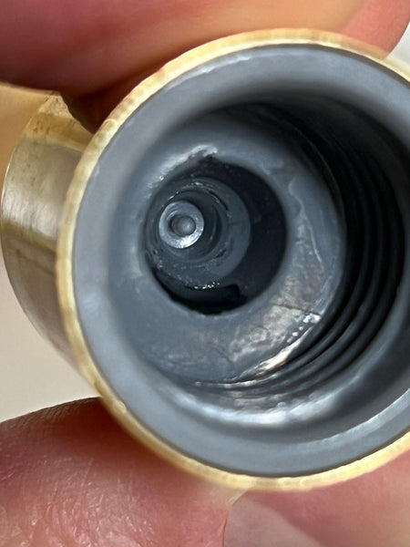 the inside of an eyelash extensions glue lid showing the nib that keeps the bottle airtight
