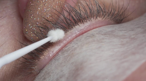 A close up photo of the lash line during pre-treatment, old makeup can be seen on the skin between the lashes | London Lash Canada