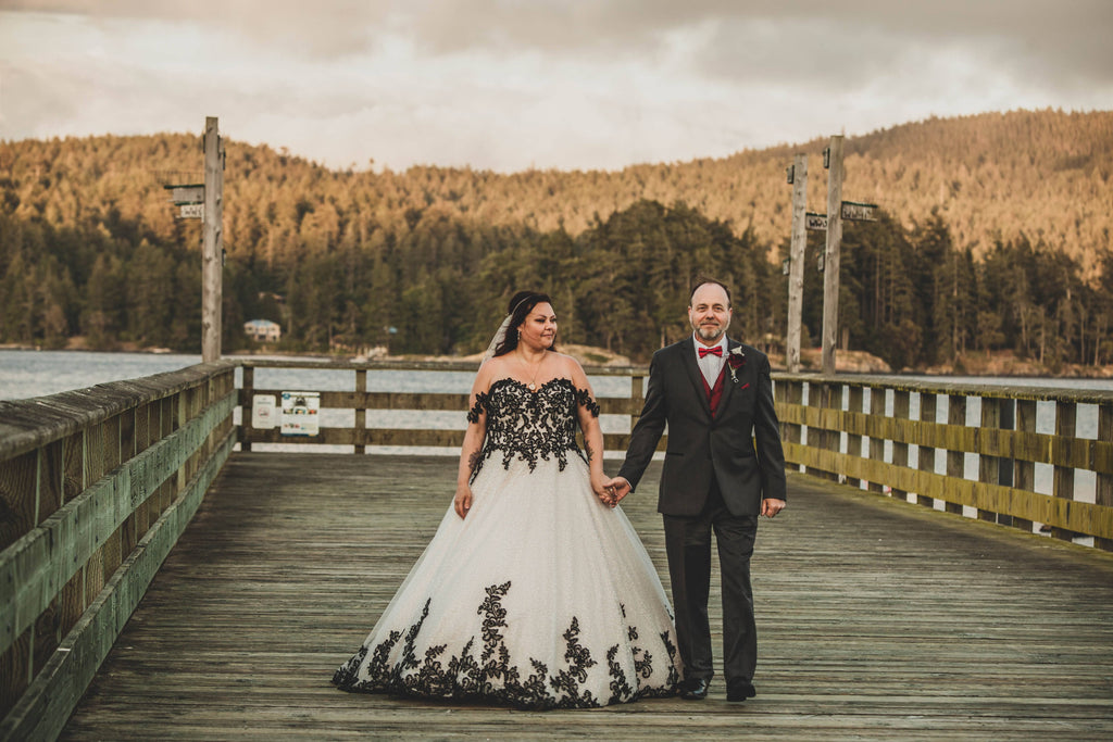 bride and groom walking down a wooden dock