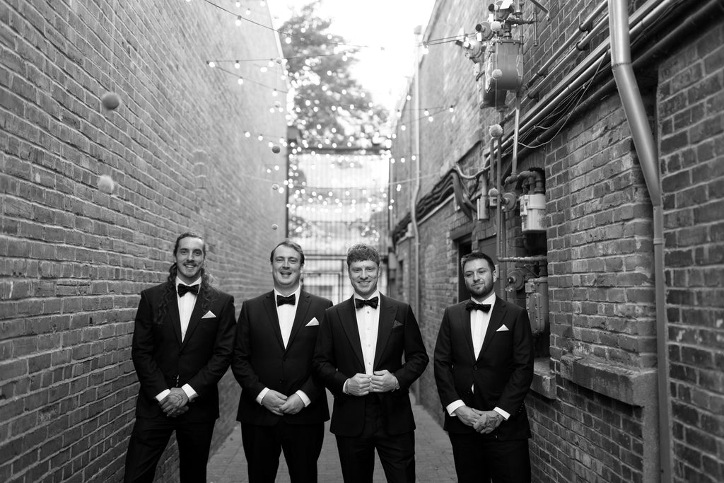 men in suits standing in a stone alley at Fort Commons