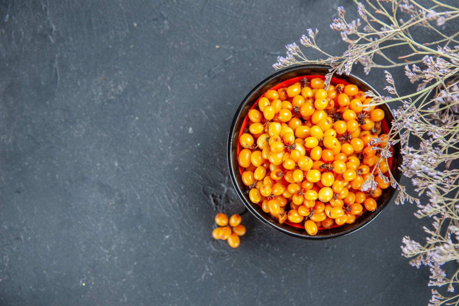 top-view-sea-buckthorn-bowl-dried-flower-branch-dark-red-table-free-place
