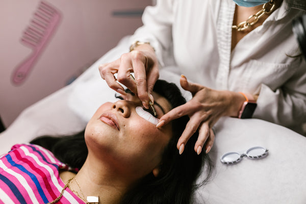 Lash technician applying lash extensions on a woman