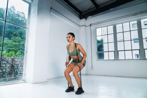 woman doing squat practicing with bands