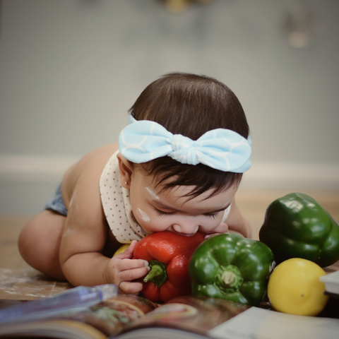 Bébé qui mange toute seule en croquant directement dans des légumes frais