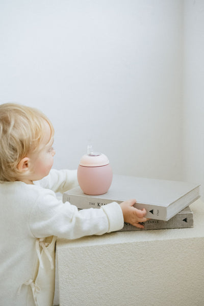 un enfant prend sa gourde elhee sur un meuble design