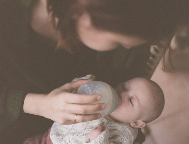 Infant drinking an Élhée anti-colic bottle