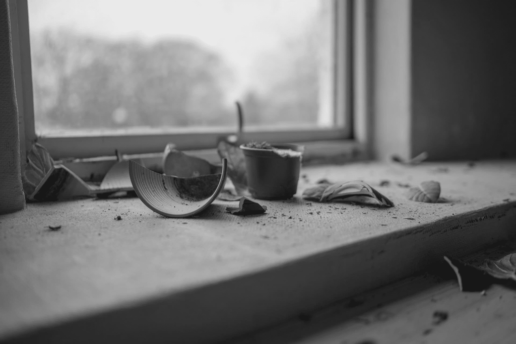 a broken cup on a window sill