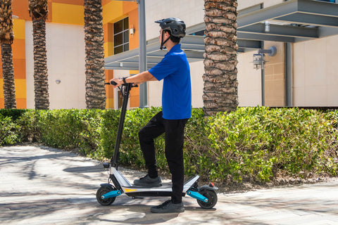 man riding electric scooter with helmet