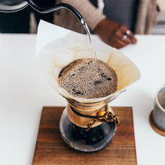 Langsamer Kaffee, der Wasser auf Kaffee gießt