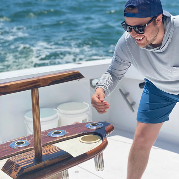 Man smiling and having a good time as he plays Hooks! on a boat during the summer