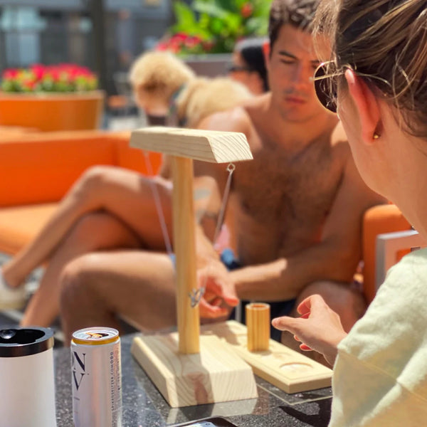 Friends sitting and playing a game of Hooks! by the pool, shot still placed in the middle of the ladder