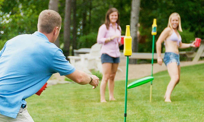 Friends hanging out in backyard playing Bottle Bash throwing disc at opponents bottle