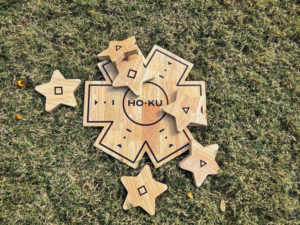 Hoku board game on the grass with throwing stars on top