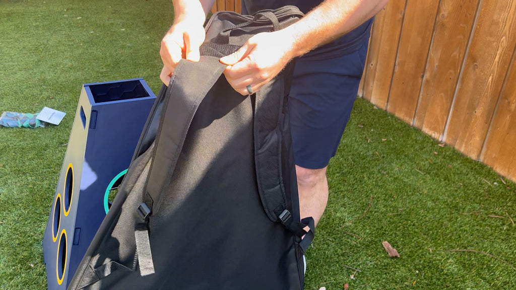 Person stands in backyard holding TowerBall Nylon Backpack.