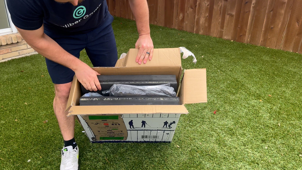 Man stands in backyard opening Putterball box.